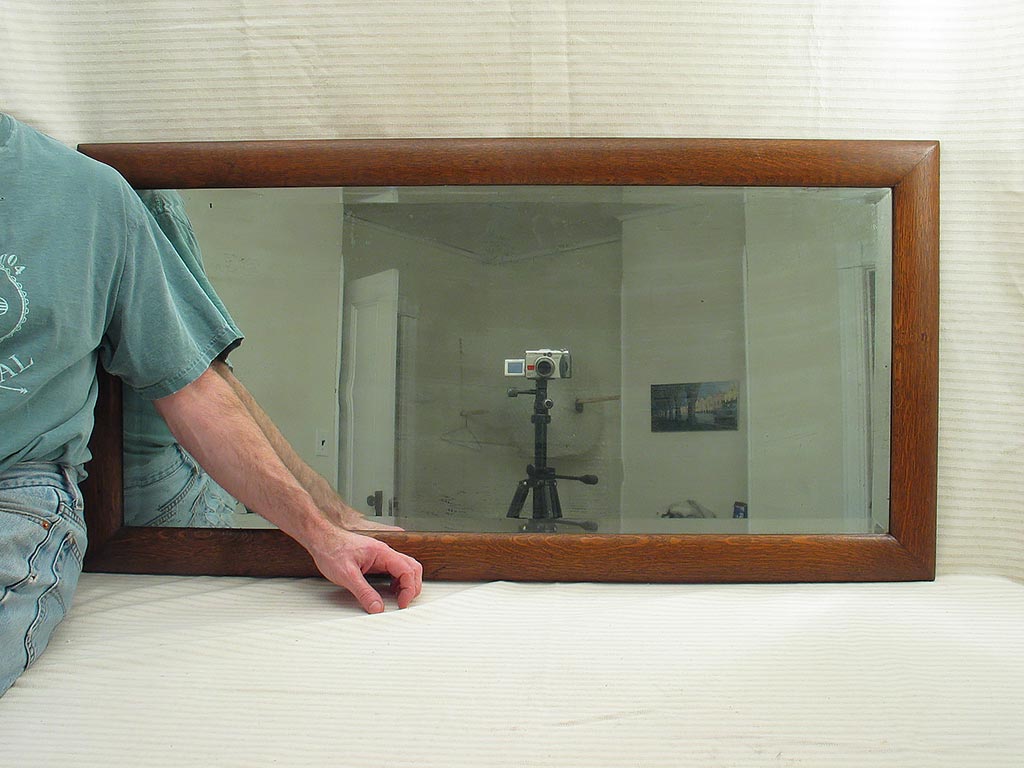 Antique bevel glass mirror in a golden oak wood frame